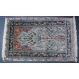 A Persian silk fine weave Hereke rug, the cream ground decorated with a central vase issuing flowers