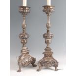 A pair of 19th century white metal alter sticks, in the 17th century Baroque style, having multi-