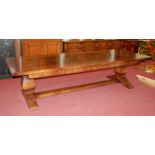 An Elizabethan style oak refectory table with twelve dining chairs, the table having a four-plank