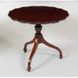 A mahogany pedestal wine table, having a circular shaped dish top and raised on umbrella legs with