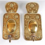 A pair of Dutch embossed brass single light wall sconces, each decorated with stylised flowers in