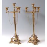 A pair of gilt brass four-light candelabra, the candle-holders each having detachable sconces, on