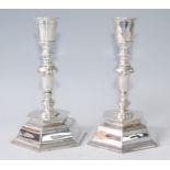 A pair of silver candlesticks in the 17th century style, having multi-knopped columns to domed