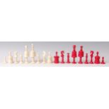 A 19th century English carved bone chess set, one side stained red and the other left natural,