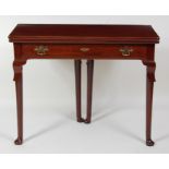 A George II mahogany tea table, having a fold-over top on gateleg rear action, above a single frieze