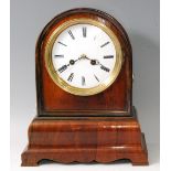 A Victorian rosewood dome topped mantel clock, having an unsigned white enamel dial, twin winding