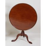 A George III mahogany pedestal tripod table, having a dished circular tilt-top to a gun barrel