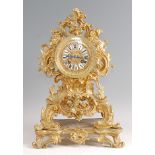 A Rococo Revival gilt brass mantel clock, the balloon shaped swept case having central dial with