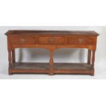 An 18th century joined elm and oak dresser base, of small proportions, having a single plank top