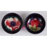 A near-pair of Moorcroft pottery circular miniature footed bowls, each underglaze painted and tube-