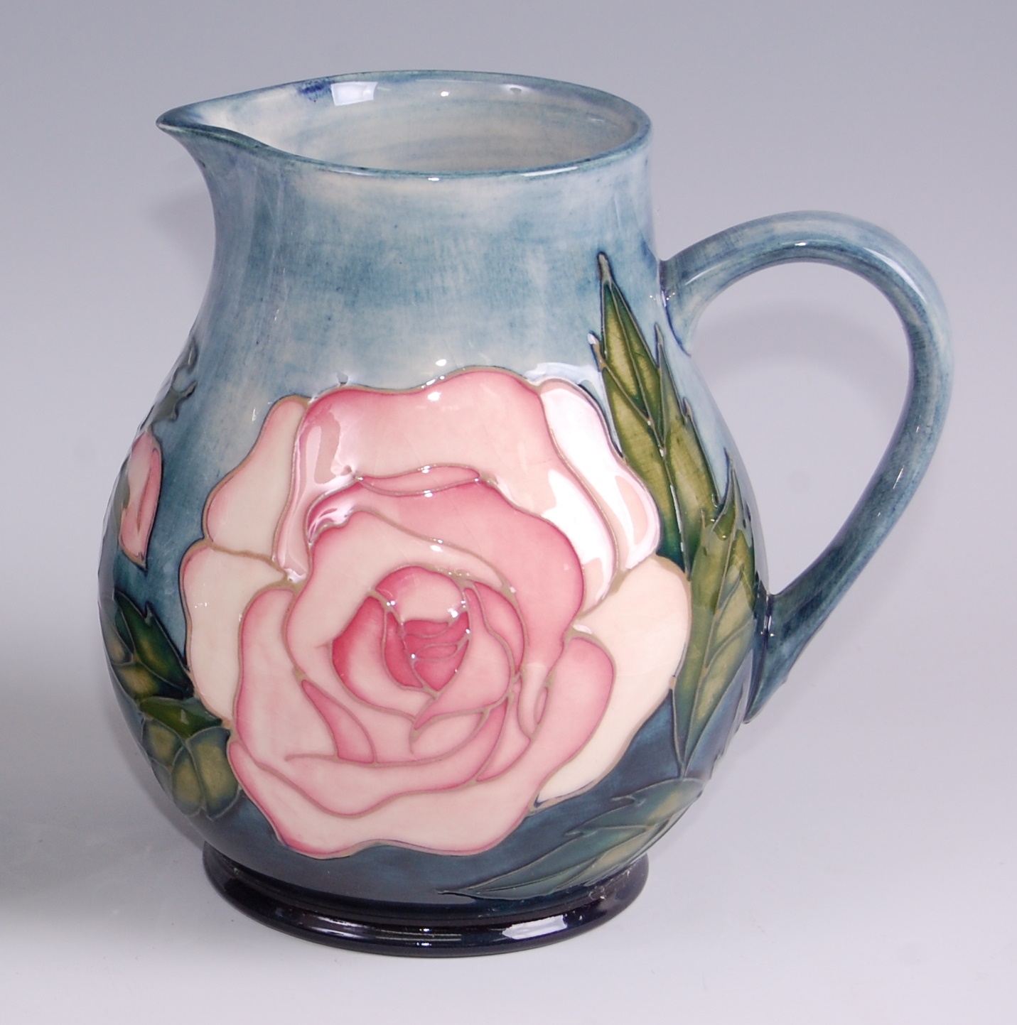 A contemporary Moorcroft pottery jug in the Pink Roses pattern, of slightly bulbous form, underglaze