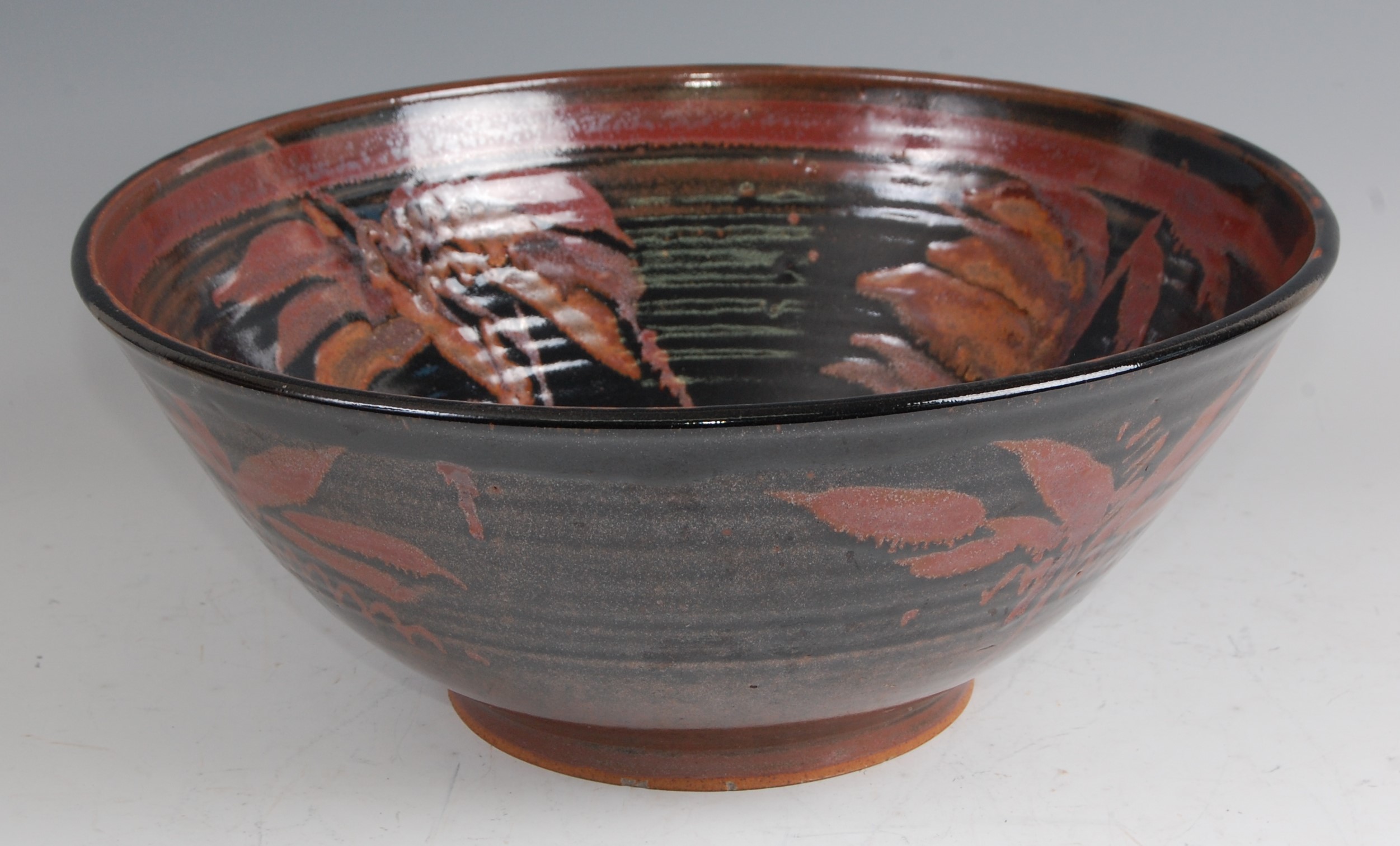 A large contemporary studio pottery circular table bowl, the ribbed body underglaze painted with