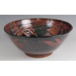 A large contemporary studio pottery circular table bowl, the ribbed body underglaze painted with