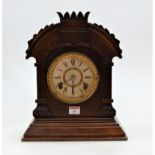 A late 19th century American walnut cased mantel clock by the Ansona Clock Company having a paper