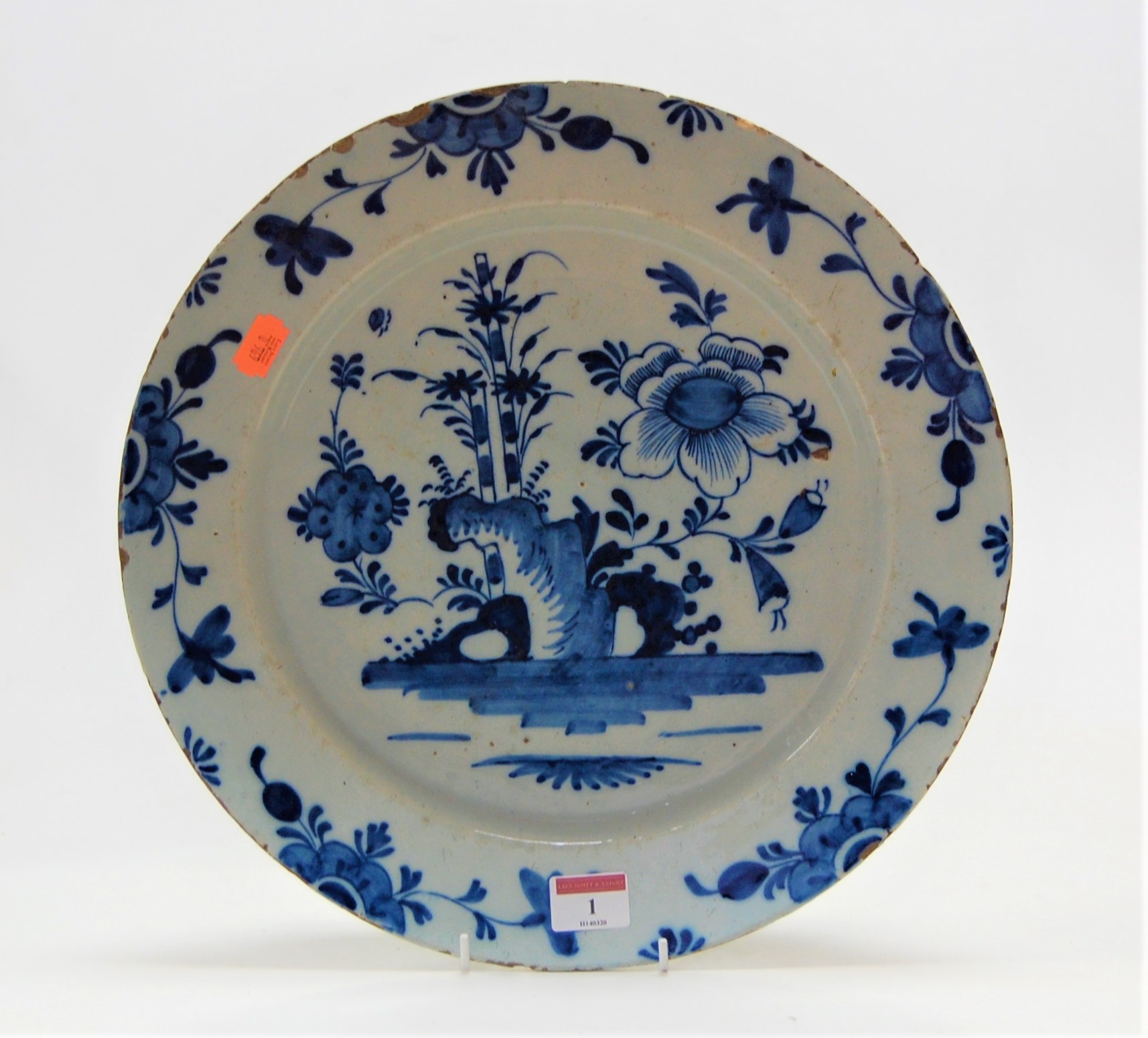 An 18th century English Delft blue & white charger, the centre typically decorated with flowers