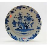 An 18th century English Delft blue & white charger, the centre typically decorated with flowers