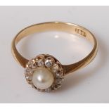 An 18ct gold, cultured pearl and diamond dress ring, the single pearl in a surround of twelve