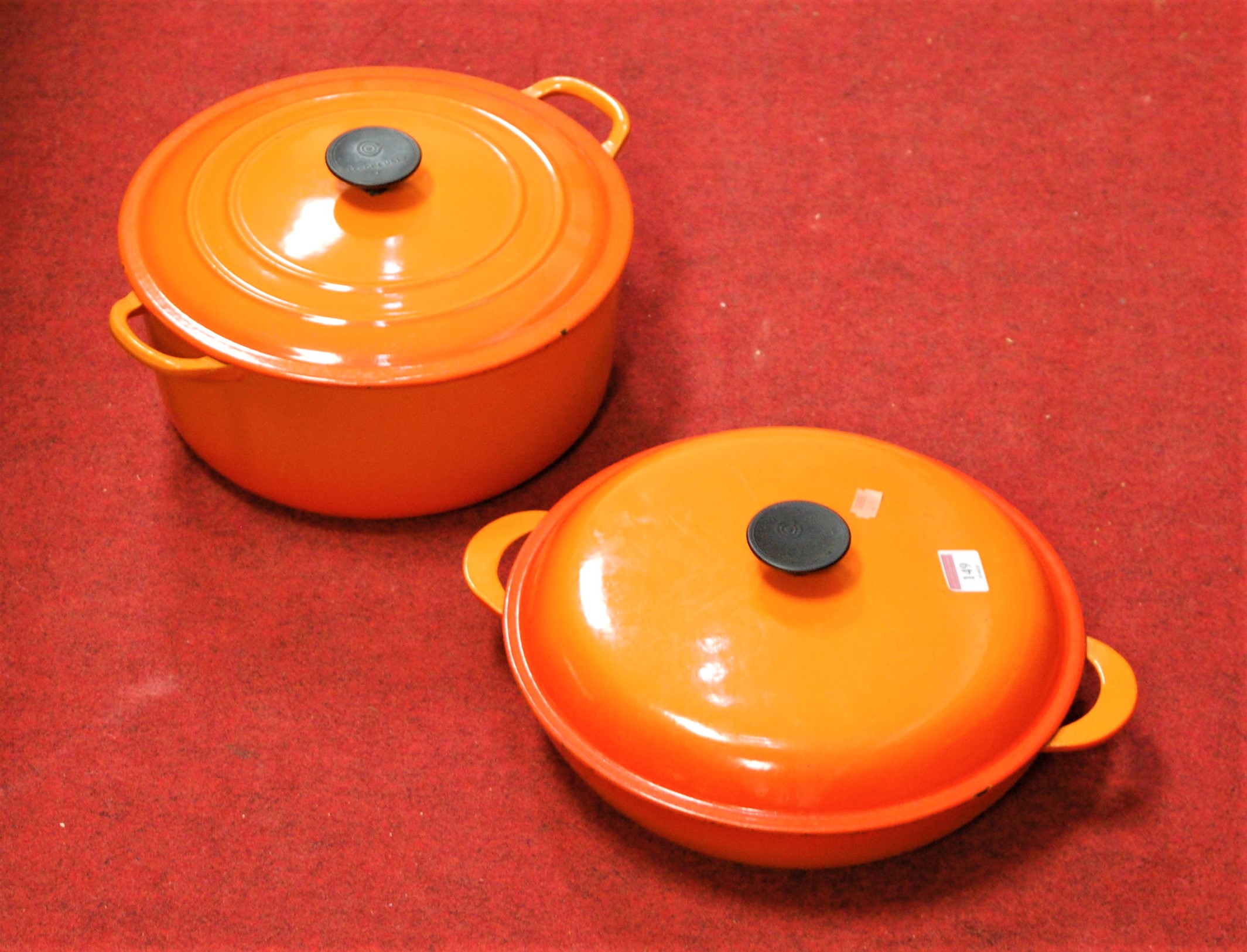 A Le Creuset orange enamelled casserole dish and cover together with one other smaller example (2)