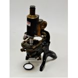 A circa 1900 lacquered brass and iron monocular microscope, stamped to the arm J Swift & Son, London