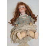 An Armand Marseille bisque head doll, having fixed blue eyes and open mouth with four top teeth