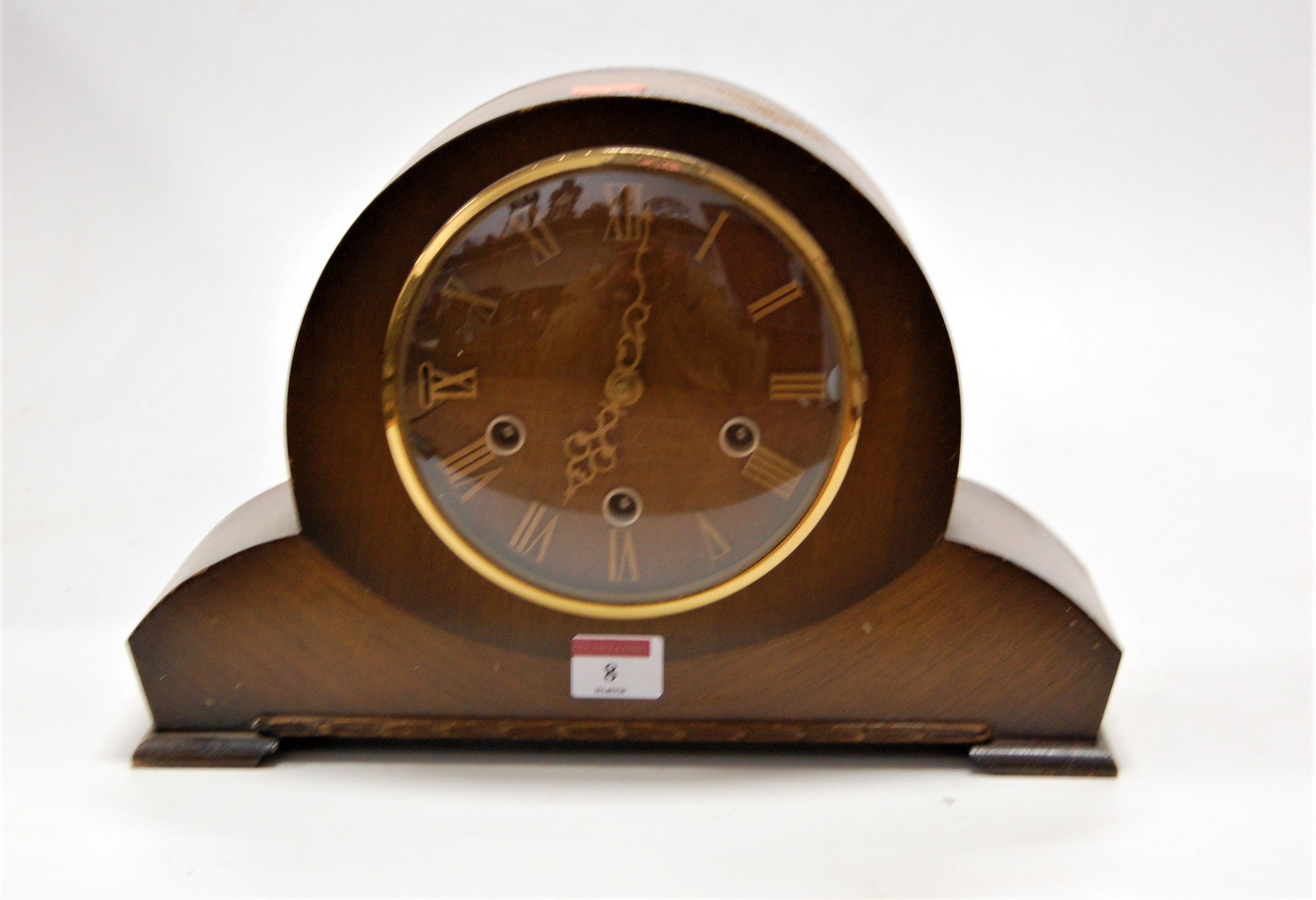 A 1950s oak cased mantel clock having raised Roman numerals and chiming movement