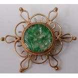 A carved green and celadon jade flower head disc, in 9ct gold mount as a brooch, 7.4g, dia.4cm
