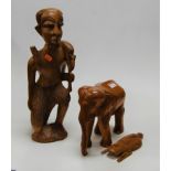 A large carved tribal style figure of a man together with a carved teak figure of an elephant, and