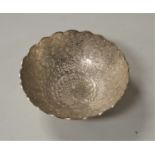 An early 20th century Indo-Persian white metal bowl, the centre relief decorated with a peacock