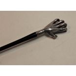 A modern novelty back-stretcher, having ebony handle, the silver terminal in the form of a hand,