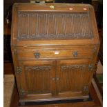 A contemporary Old Charm linenfold and moulded oak slopefront writing bureau, having single frieze