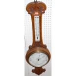 An early 20th century relief carved oak aneroid two-dial wheel barometer