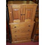 A modern pine tallboy chest of small proportions, having twin upper doors over four long drawers,