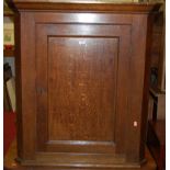 An early 19th century provincial oak single door hanging corner cupboard, width 82cm