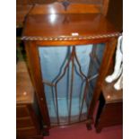 A 1930s walnut ledge back single door glazed bowfront display cabinet, having a gadrooned edge,