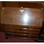 A George III mahogany slopefront writing bureau, having a fitted interior over two short and three
