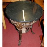 A pierced cast iron based and slate topped circular pub table, with rams mask and floral trailing