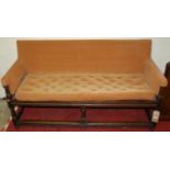 An antique joined oak framed long hall seat, upholstered with buttoned cushion, raised on ring