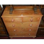 A Victorian pine chest of two short over three long drawers, raised on turned squat supports,