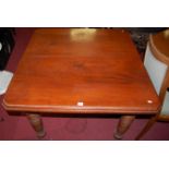 An Edwardian walnut extending dining table, having wind-out action and single extra drop-in leaf,