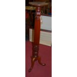 An early 20th century mahogany circular top pedestal plant-stand, the column of reeded and