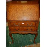 A 1930s walnut and figured walnut lady's slopefront two-drawer writing bureau, having a fitted