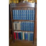 A 1930s oak low free standing open bookshelf to include; The Works of Charles Dickens and other