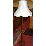 An early 20th century turned mahogany standard lamp, having reeded detail with silk shade, overall