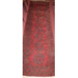 A Persian woollen red ground Bokhara hall runner, 280 x 80cm