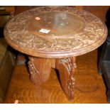 A small Eastern relief carved teak and brass wirework inset circular low occasional table, dia.
