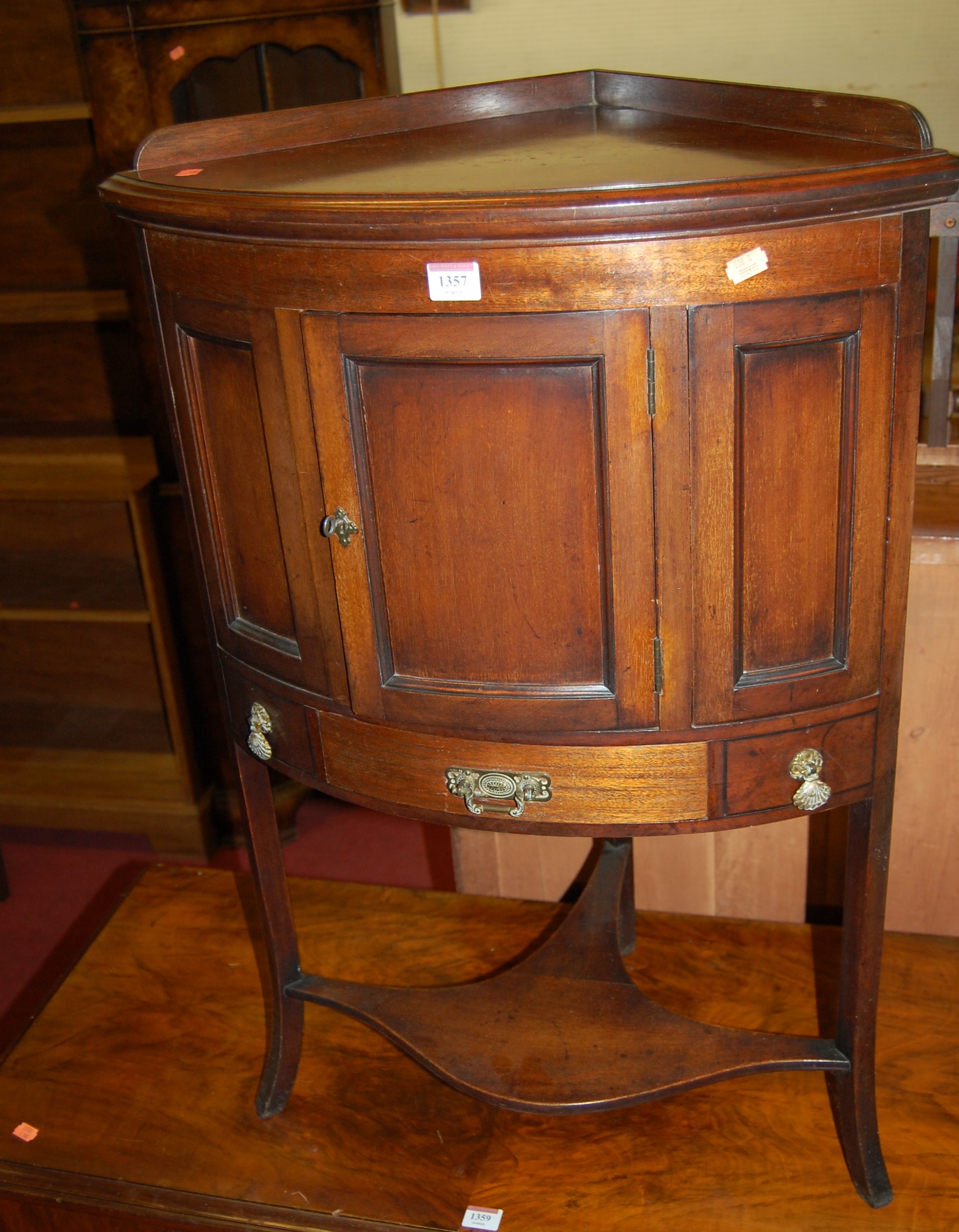 A 19th century mahogany corner wash stand, having single cupboard door to platform undertier,