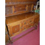 An early 20th century geometric moulded oak sideboard, having a raised and panelled back