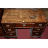 An Art Deco oak kneehole writing desk having an arrangement of seven drawers, width 104cm