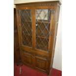 A contemporary Old Charm linenfold moulded oak lead glazed display cabinet, width 100cm