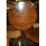 A George III mahogany circular tilt-top pedestal tripod table, raised on plain turned column to